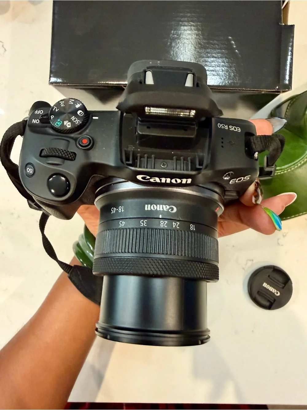 Canon EOS R50 Black Mirrorless Camera with Red-Trim Strap and Green Case